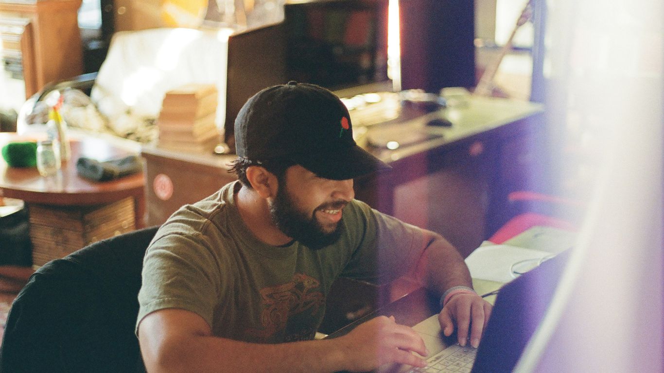 A man works at his desk indoors.