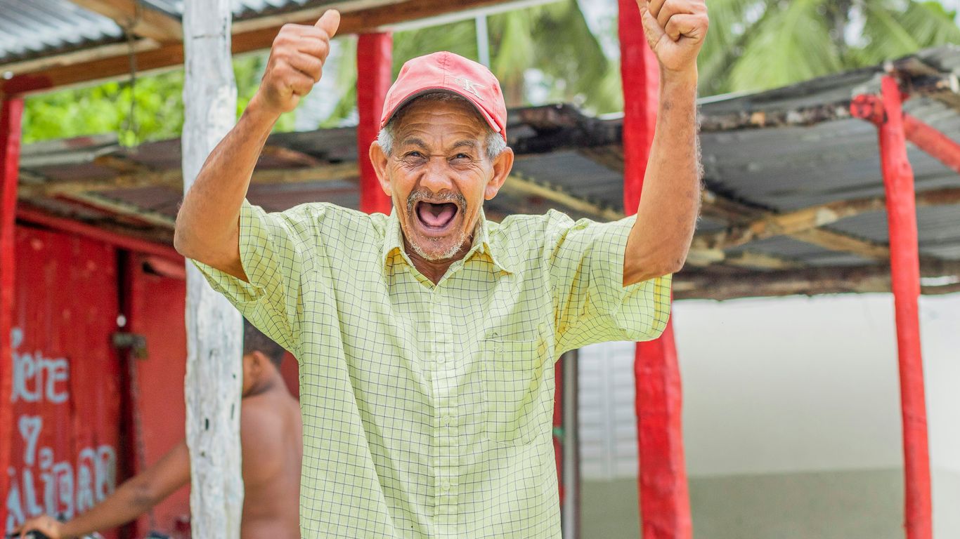 a man with a pink hat is raising his hands